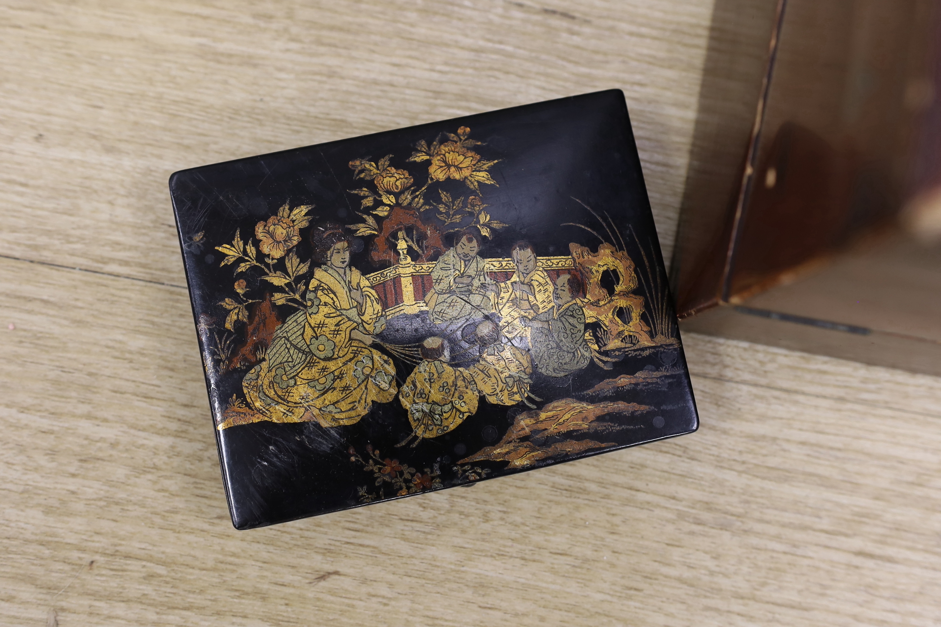 A Japanese lacquer writing box and three black lacquer or papier mache boxes